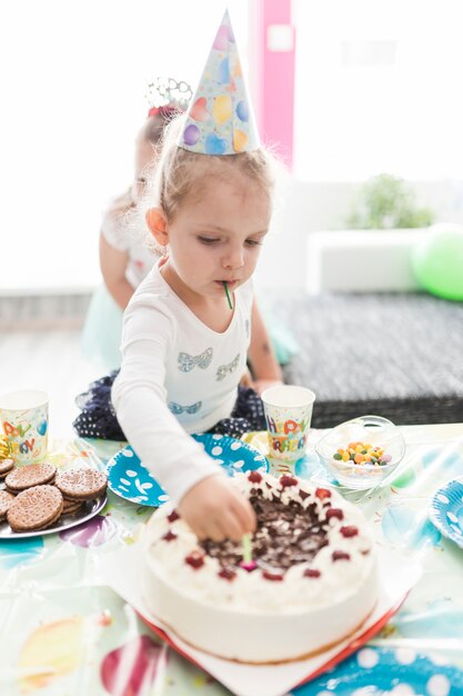 Jolie fille prenant des bougies de gâteau