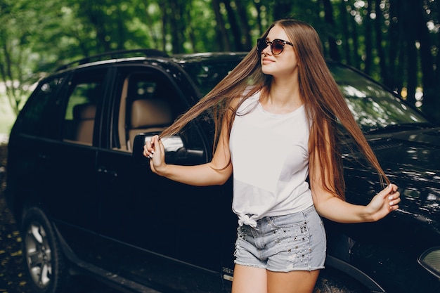 Photo gratuite jolie fille près d'une voiture