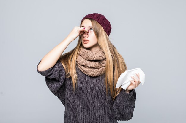 Jolie fille en pull gris avait mal de tête de grippe froide sur gris