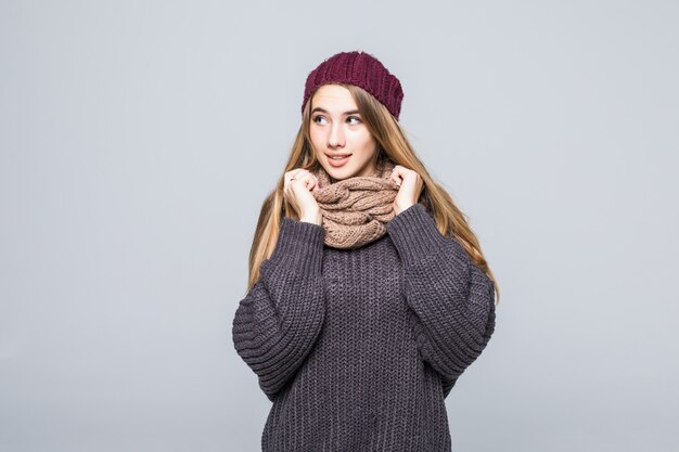 Jolie fille en pull gris et écharpe est froide sur gris