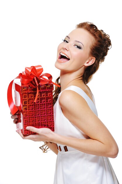 Photo gratuite jolie fille en riant tenant la boîte rouge présente sur fond blanc