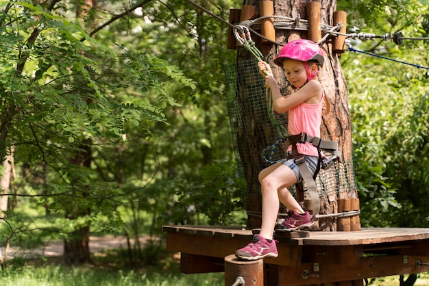 Jolie fille s'amusant dans un parc d'aventure