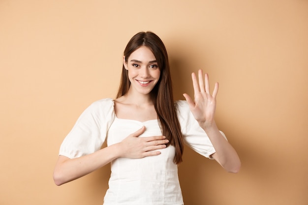 Une jolie fille souriante fait la promesse de mettre la main sur le cœur et de dire la vérité en étant honnête en vous jurant debout...