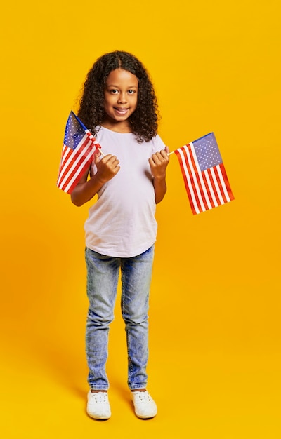 Jolie fille tenant des drapeaux américains