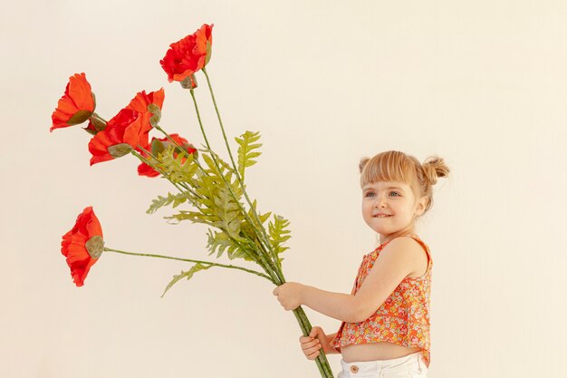 Jolie fille tenant de grandes fleurs