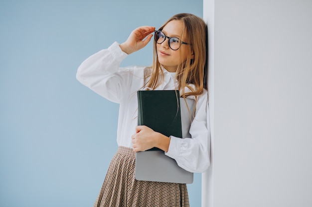 Jolie fille tenant un livre et un ordinateur portable au bureau