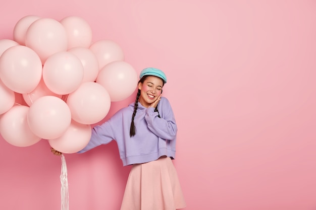 Une Jolie Japonaise Ravie Garde Les Yeux Fermés, Prend Plaisir à Recevoir Des Félicitations Pour Son Entrée à L'université, Tient Des Ballons