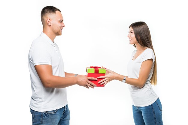 Jolie jeune couple avec surprise boîte cadeau rouge isolé sur blanc