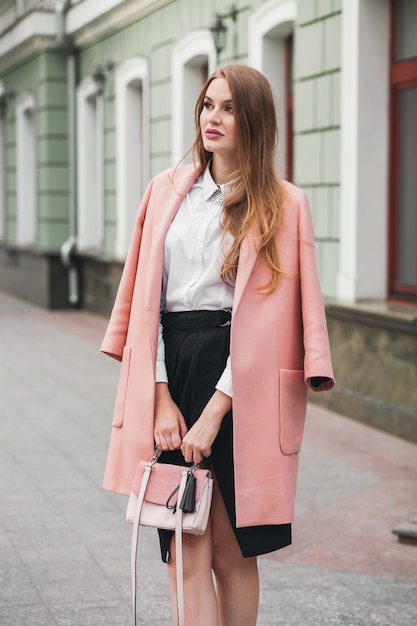 Jolie jeune et élégante belle femme marchant dans la rue, portant manteau rose, sac à main, chemise blanche, jupe noire, tenue de mode, tendance automne, souriant heureux, accessoires