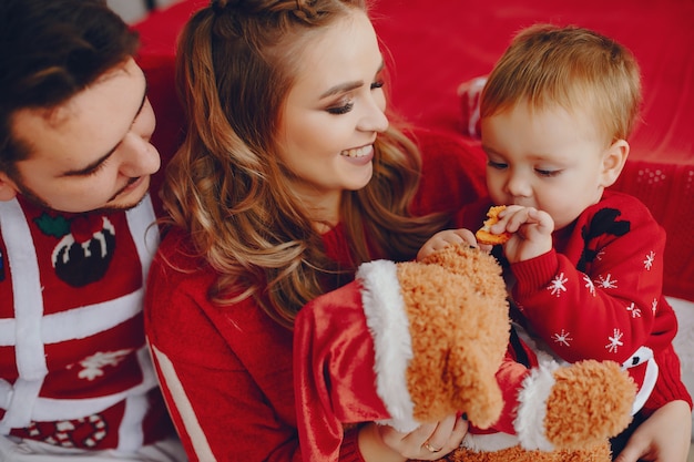 Photo gratuite jolie jeune famille assis à la maison sur un lit