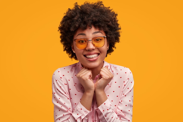 Photo gratuit une jolie jeune femme aux cheveux bouclés.