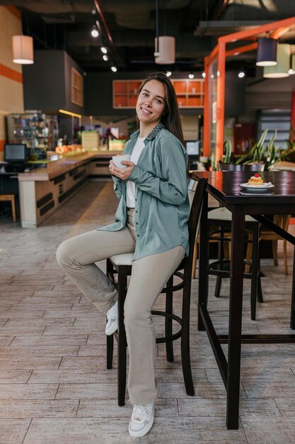 Jolie jeune femme bénéficiant d'une tasse de café