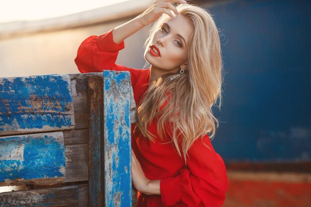 jolie jeune femme blonde en robe rouge en plein air