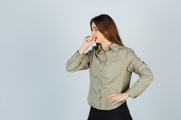 Jolie jeune femme en chemise, jupe souffrant de toux et ayant l'air malade, vue de face.