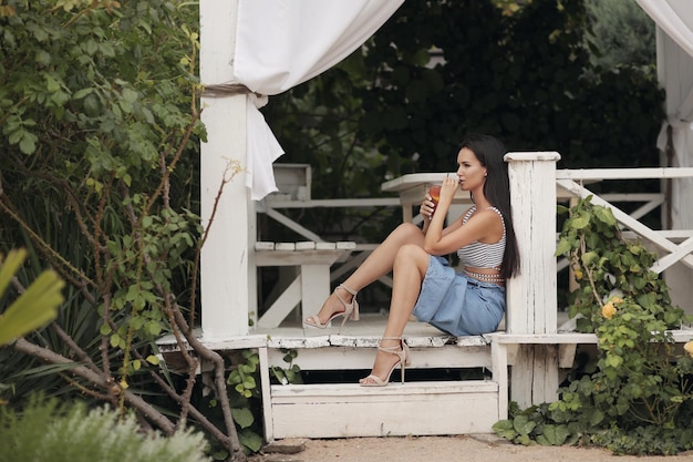 jolie jeune femme avec cocktail en plein air