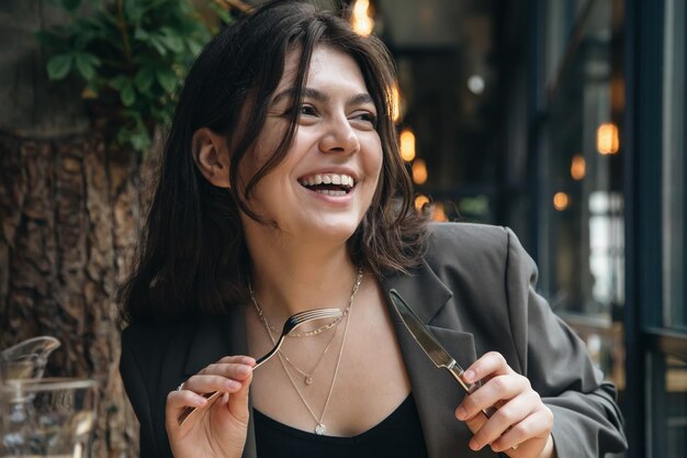 Jolie jeune femme avec des couverts dans un restaurant