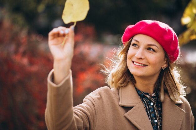 Jolie jeune femme dans un barret rouge à l'extérieur dans le parc