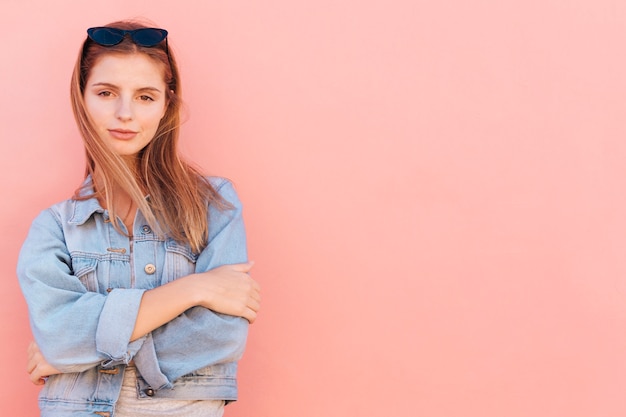 Photo gratuite une jolie jeune femme debout sur fond de pêche