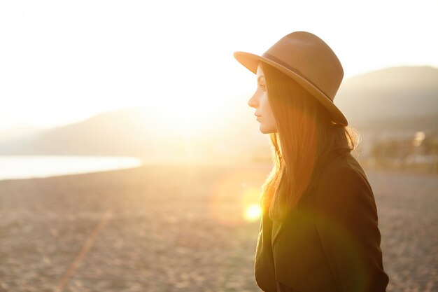 Jolie jeune femme européenne pensive portant des vêtements chauds élégants se détendre au bord de la mer