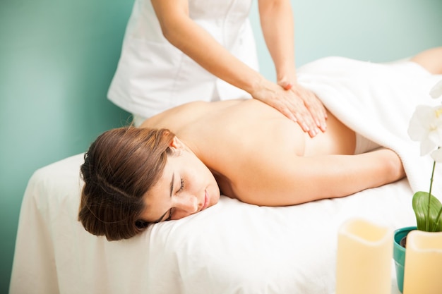 Jolie jeune femme hispanique recevant un massage du dos d'une thérapeute dans un spa