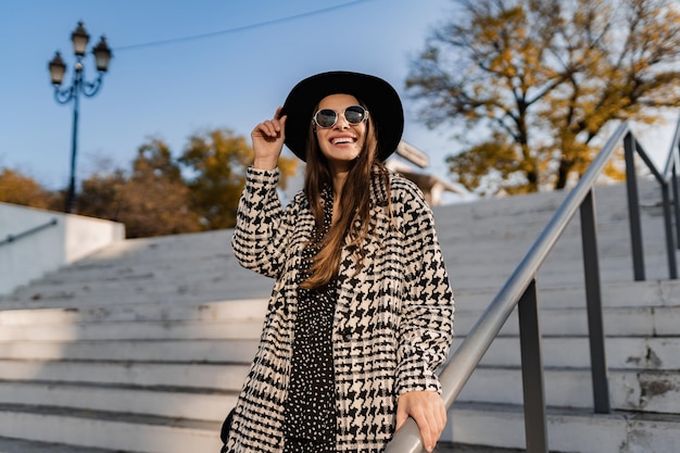 Jolie jeune femme marchant en automne portant un manteau