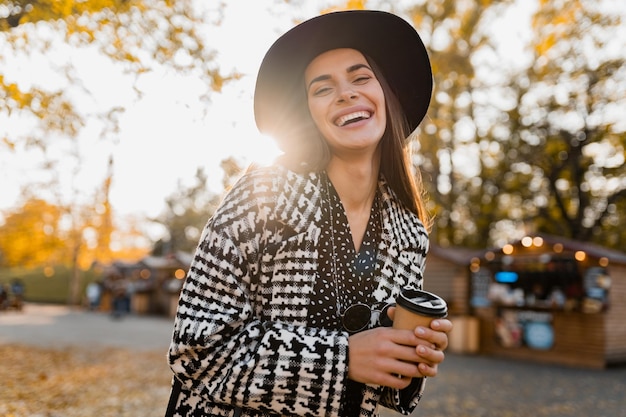 Jolie jeune femme marchant en automne portant un manteau