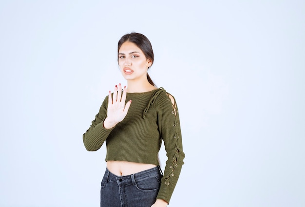 Jolie jeune femme médiatrice avec une expression sérieuse sur un mur blanc