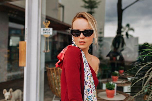 Jolie jeune femme à la mode portant des lunettes de soleil noires