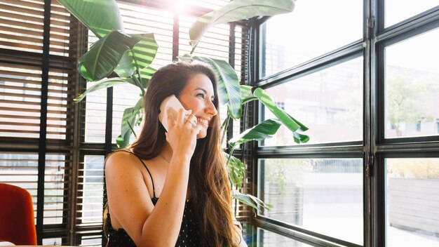 Une jolie jeune femme parlant au téléphone intelligent