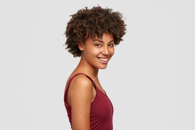 Jolie jeune femme à la peau foncée avec une coiffure afro, vêtue de vêtements décontractés