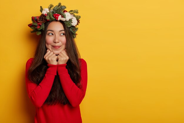 Jolie et jeune femme portant une couronne de Noël sur sa tête