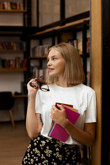 Jolie jeune femme posant à la bibliothèque