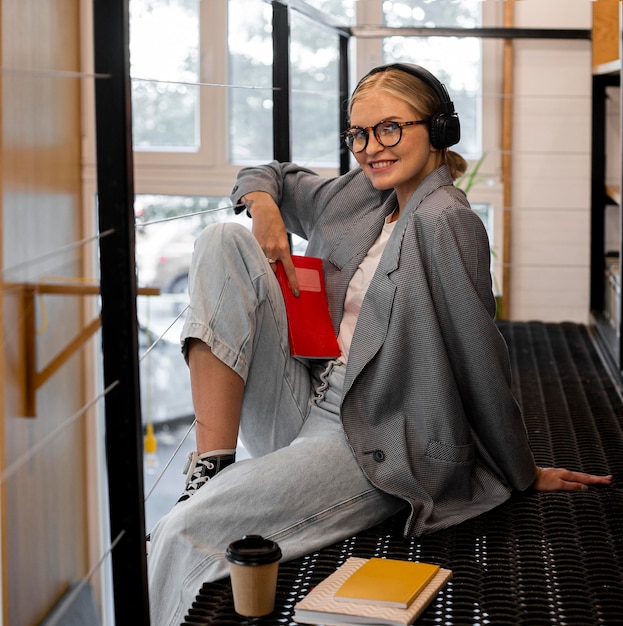 Jolie jeune femme posant à la bibliothèque