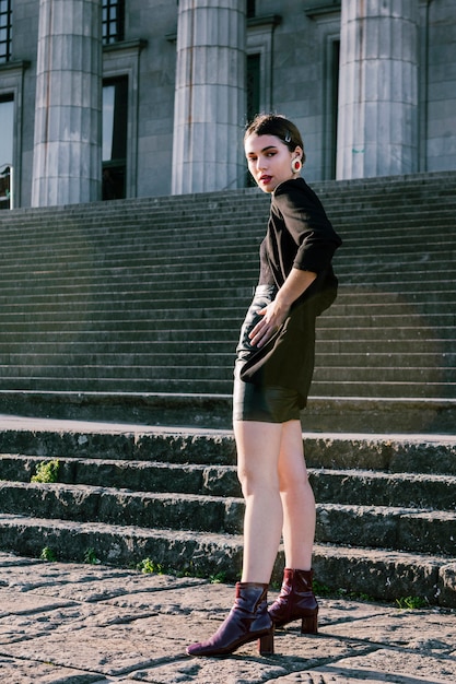 Une jolie jeune femme posant devant l&#39;escalier avec la main sur les hanches