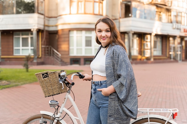 Jolie jeune femme posant avec vélo