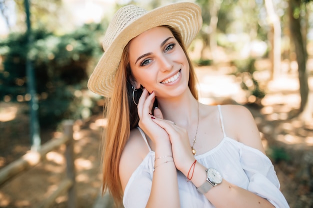 Jolie jeune femme profitant de son temps à l'extérieur dans le parc avec coucher de soleil en arrière-plan.