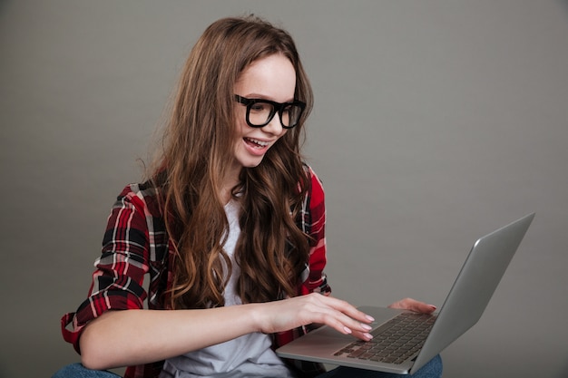 Jolie jeune femme souriante discutant par ordinateur portable