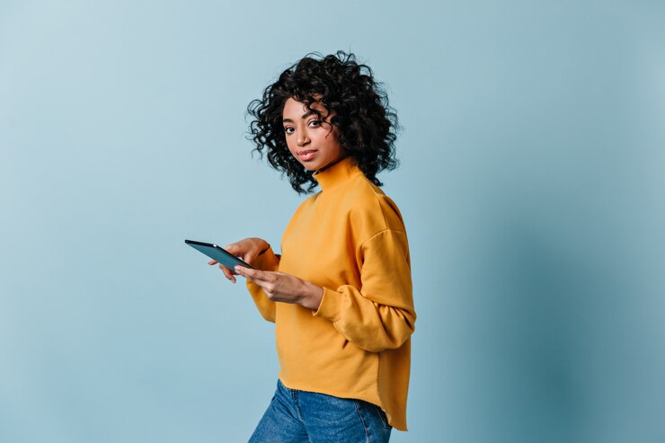 Photo gratuit jolie jeune femme tenant une tablette numérique