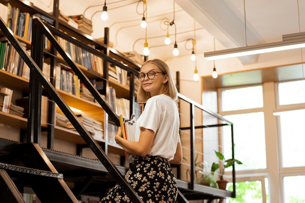 Jolie jeune fille à la bibliothèque