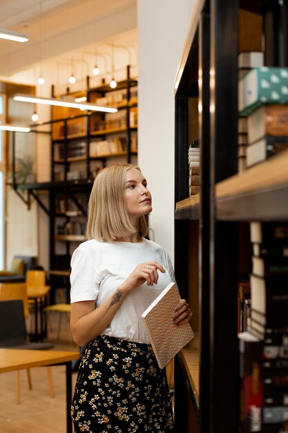 Jolie jeune fille pensant à la bibliothèque