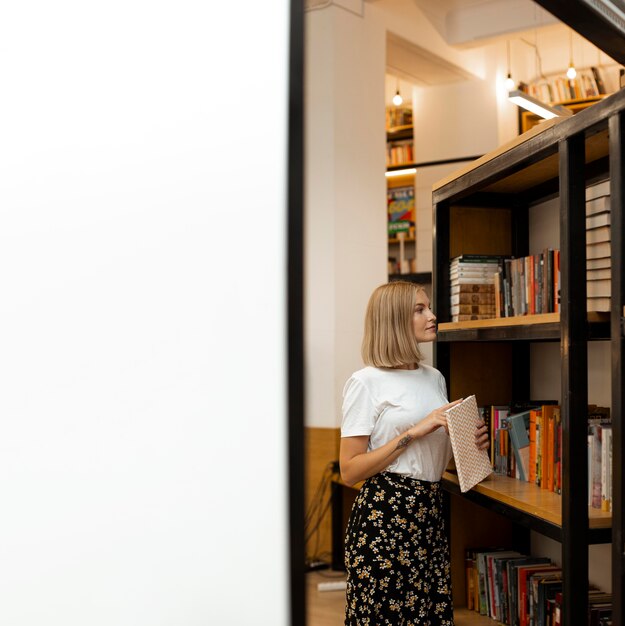 Jolie jeune fille pensant à la bibliothèque