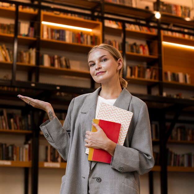 Jolie jeune fille posant à la bibliothèque