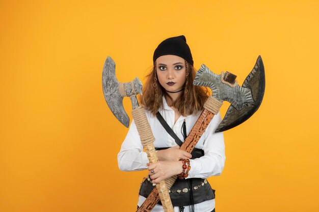 Jolie jeune fille tenant des haches et regardant la caméra. Photo de haute qualité