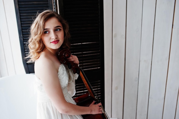 Photo gratuite jolie jeune musicienne gilrl en robe blanche avec contrebasse