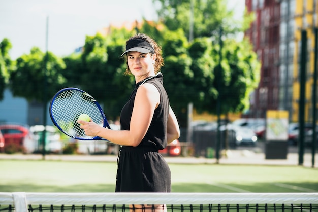 Jolie joueuse de tennis frappant la balle par une journée ensoleillée