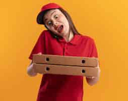 Photo gratuite jolie livreuse anxieuse en uniforme parle au téléphone et tient des boîtes à pizza