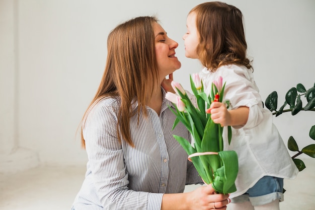Jolie mère et fille avec des fleurs de tulipes