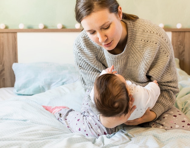 Photo gratuite jolie mère tenant un bébé dans les bras