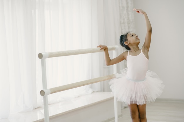 Jolie petite ballerine en costume de ballet rose. Enfant dans une pointe danse dans la salle. Enfant en cours de danse.