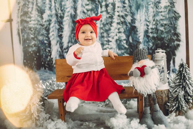 Jolie petite fille assise dans une décoration de Noël